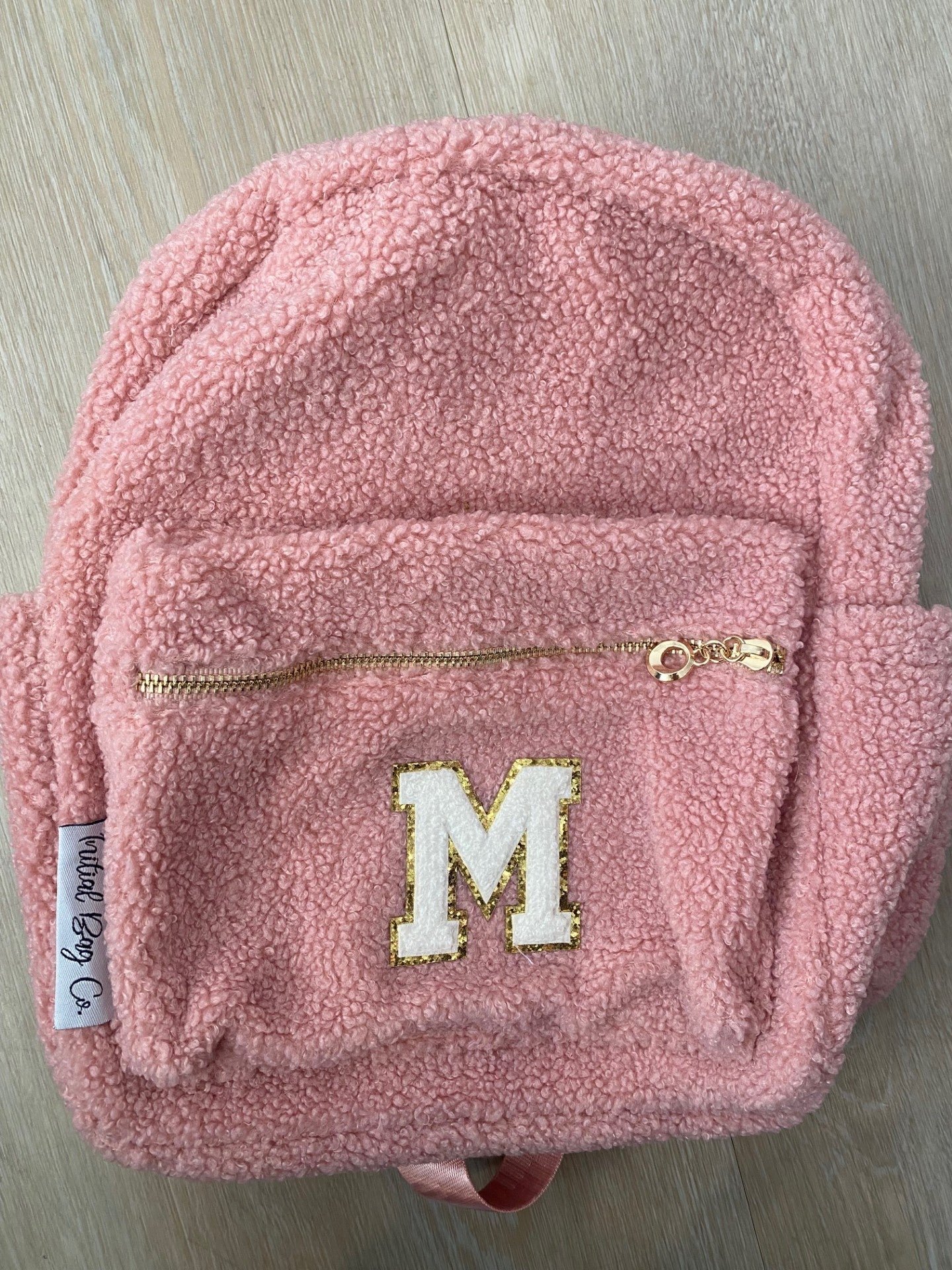 Pink with initial M in white  **SLIGHT TEAR IN MATERIAL NEAR TOP ZIP**