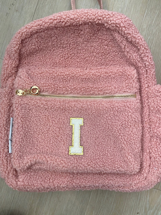 Pink backpack with initial 'I' in white **SLIGHT TEAR IN TOP MATERIAL NEAR ZIP**