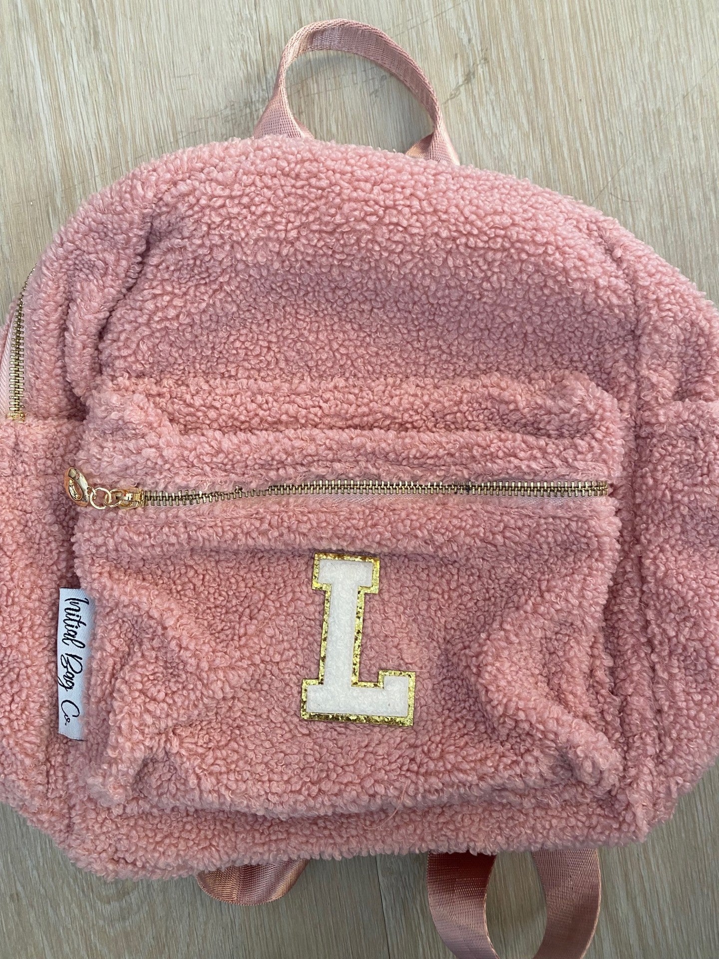 Pink backpack with initial 'L' ** BLACK MARK ON ZIP**