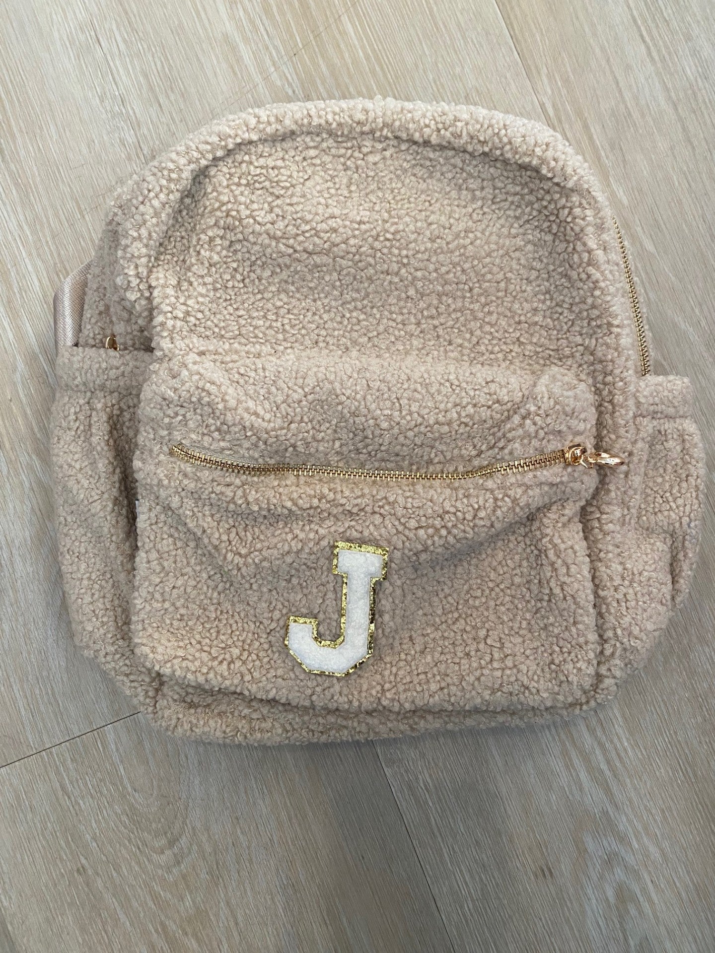 Beige backpack with initial 'J' ** ONE SIDE POCKET SLIGHTLY LARGER**