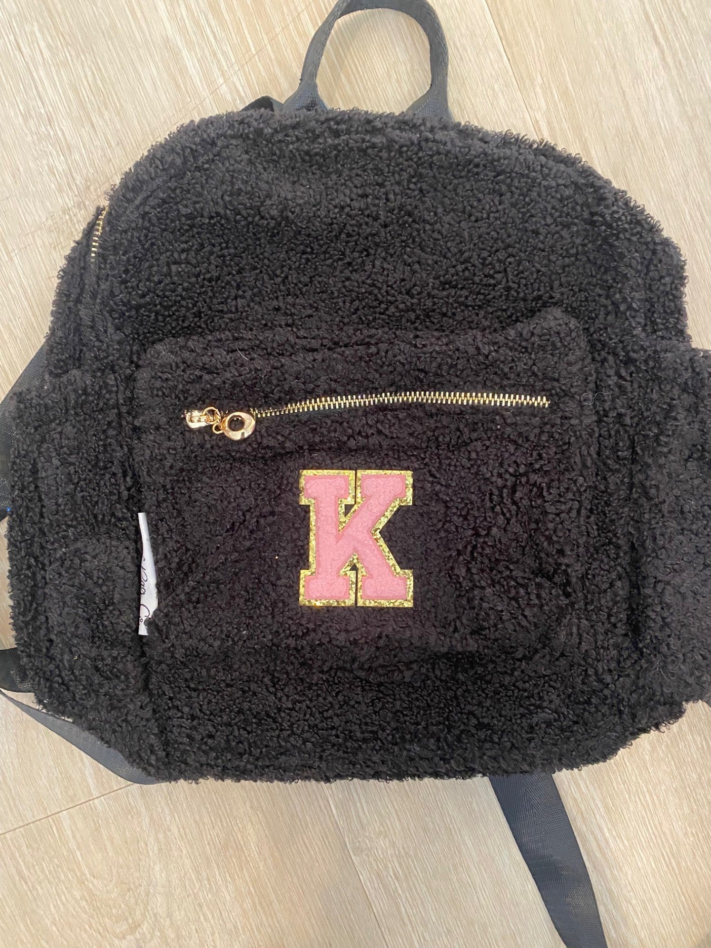 Black backpack with initial "K" in pink ** SAMPLE STOCK**