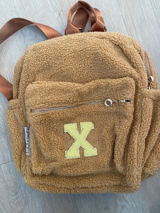 Brown backpack with initial 'X' in yellow ** SAMPLE STOCK**