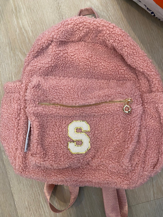 Pink backpack with initial 'S' in white **SAMPLE STOCK**