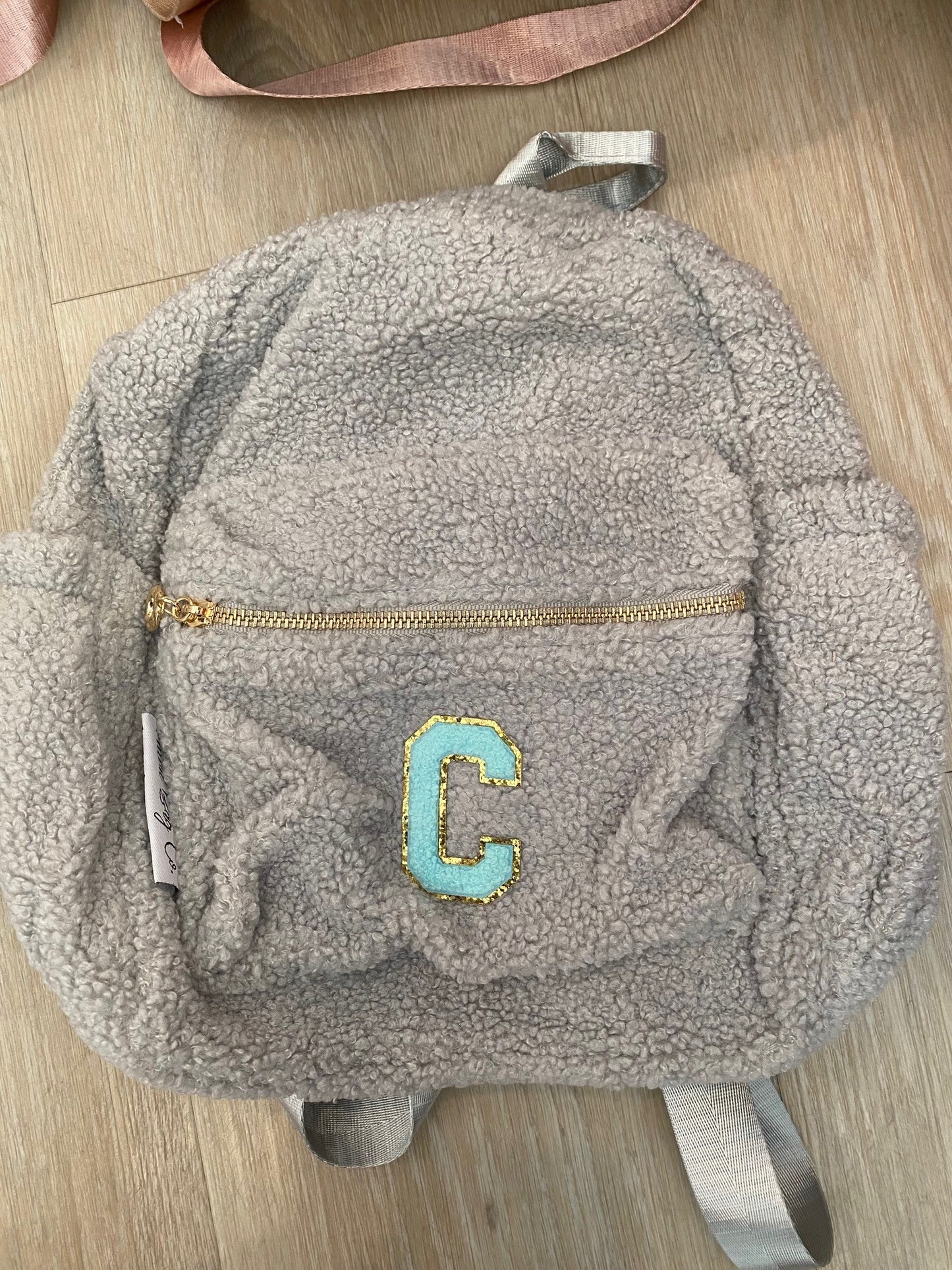 Grey backpack with initial 'C' in blue ** SAMPLE STOCK**